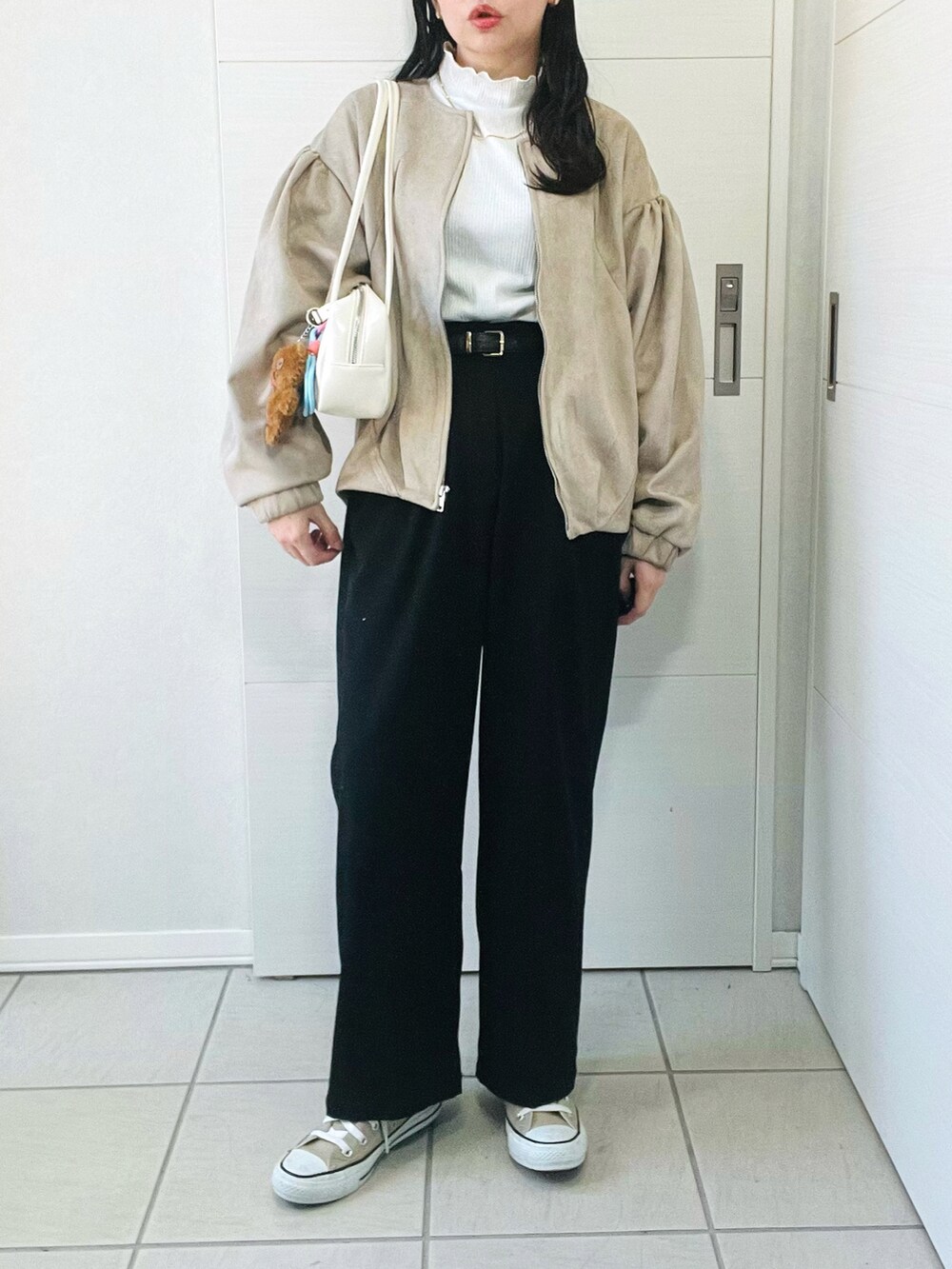 ベージュ系のブルゾン、ホワイト系のTシャツ/カットソー、ブラック系のその他パンツを着用したレディースの秋コーディネートの4枚目の写真