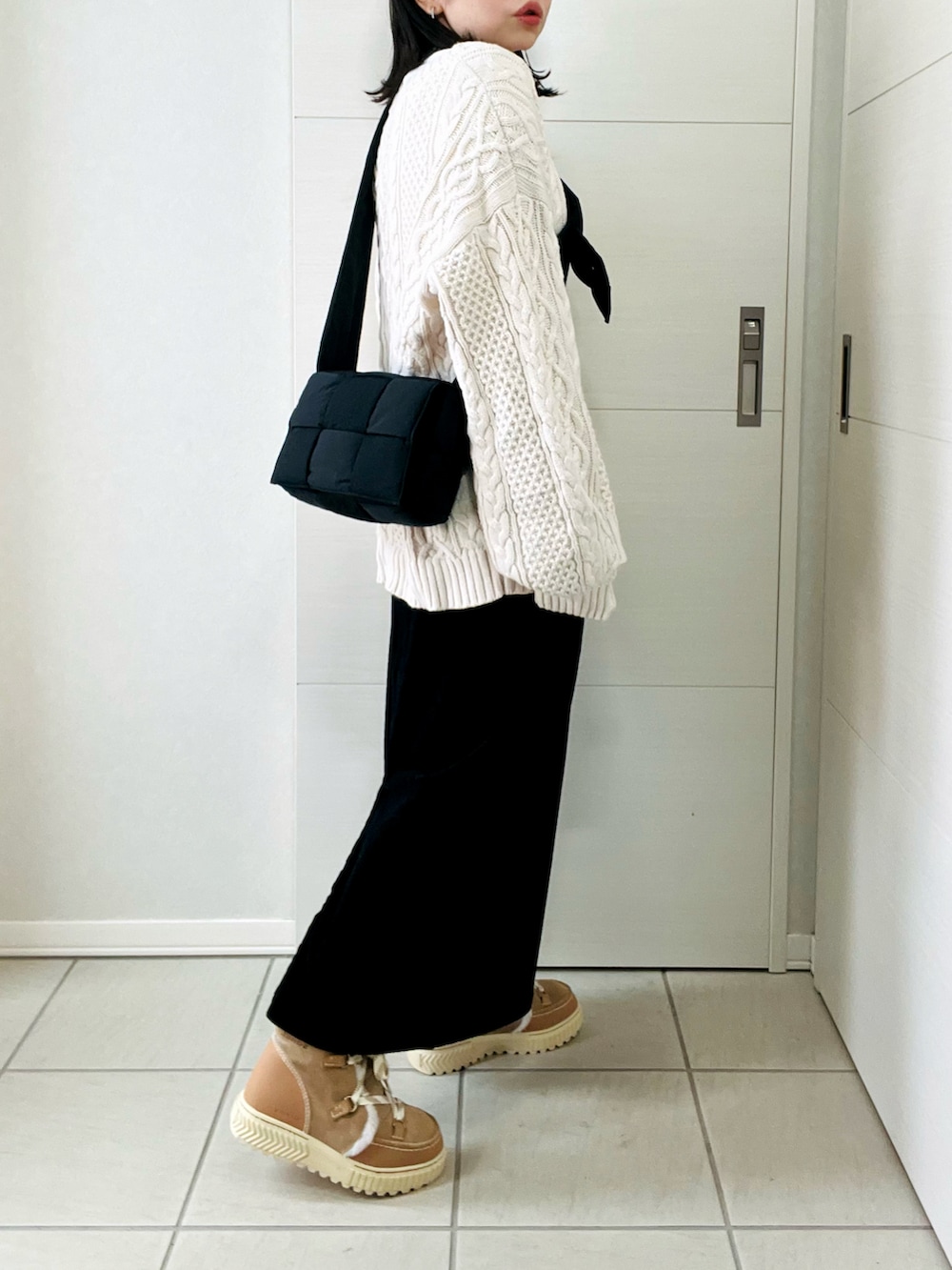 ホワイト系のニット/セーター、ブラック系のスカート、ブラウン系のブーツを着用したレディースの冬コーディネートの3枚目の写真