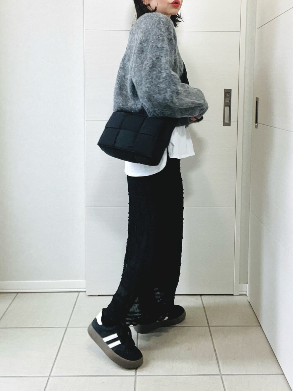 グレー系のカーディガン/ボレロ、ホワイト系のTシャツ/カットソー、ブラック系のスカートを着用したレディースの冬コーディネートの5枚目の写真