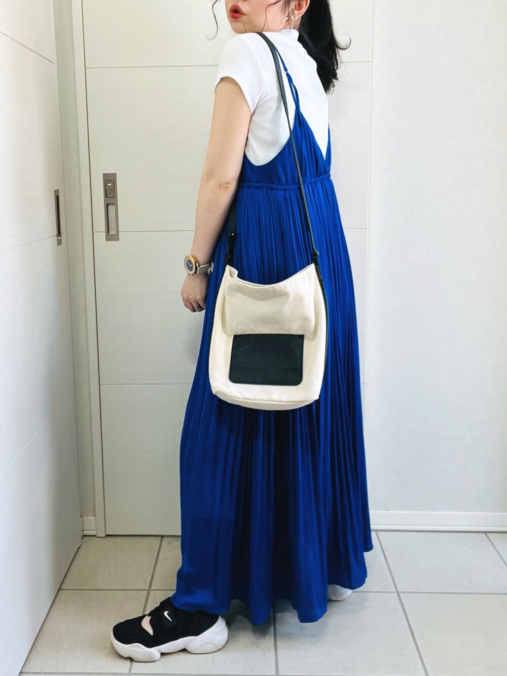 ホワイト系のTシャツ/カットソー、ブルー系のワンピース、ブラック系のスニーカーを着用したレディースの春コーディネートの5枚目の写真