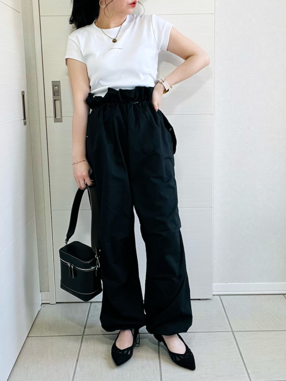 ホワイト系のTシャツ/カットソー、ブラック系のカーゴパンツ、ブラック系のパンプスを着用したレディースの春コーディネートの2枚目の写真