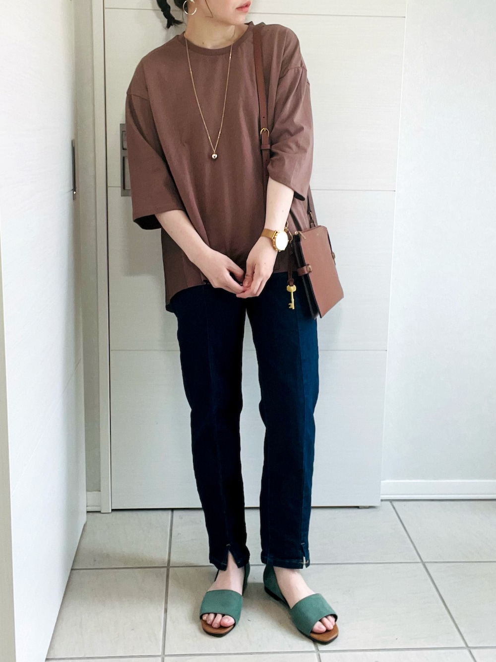 ブラウン系のTシャツ/カットソー、ブルー系のデニムパンツ、グリーン系のサンダルを着用したレディースの夏コーディネートの2枚目の写真