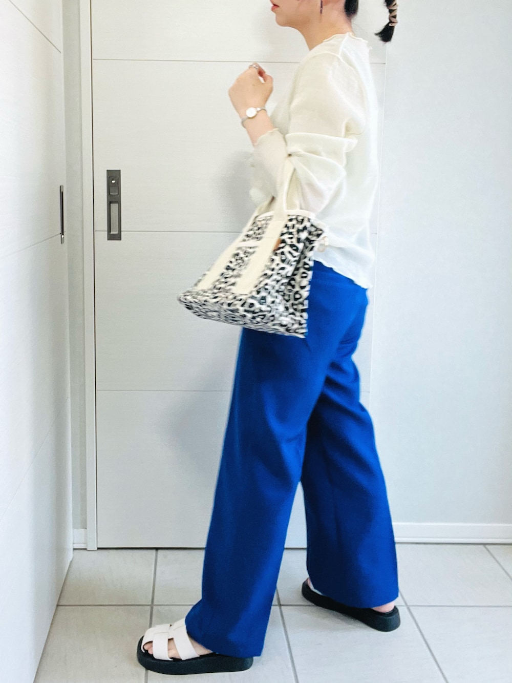 ブルー系のスラックス、ホワイト系のサンダル、その他のトートバッグを着用したレディースの春コーディネートの5枚目の写真