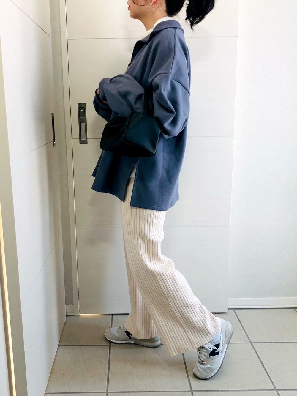 ブルー系のスウェット、ホワイト系のその他パンツ、ホワイト系のスニーカーを着用したレディースの冬コーディネートの2枚目の写真