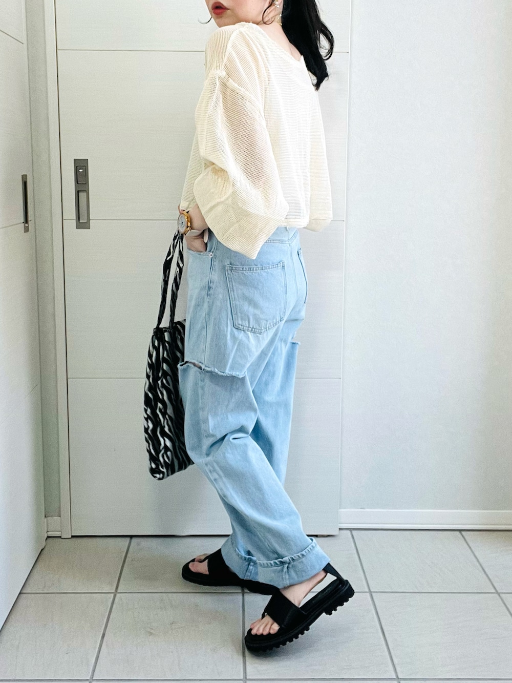 ホワイト系のカーディガン/ボレロ、ブルー系のデニムパンツ、ブラック系のサンダルを着用したレディースの春コーディネートの5枚目の写真