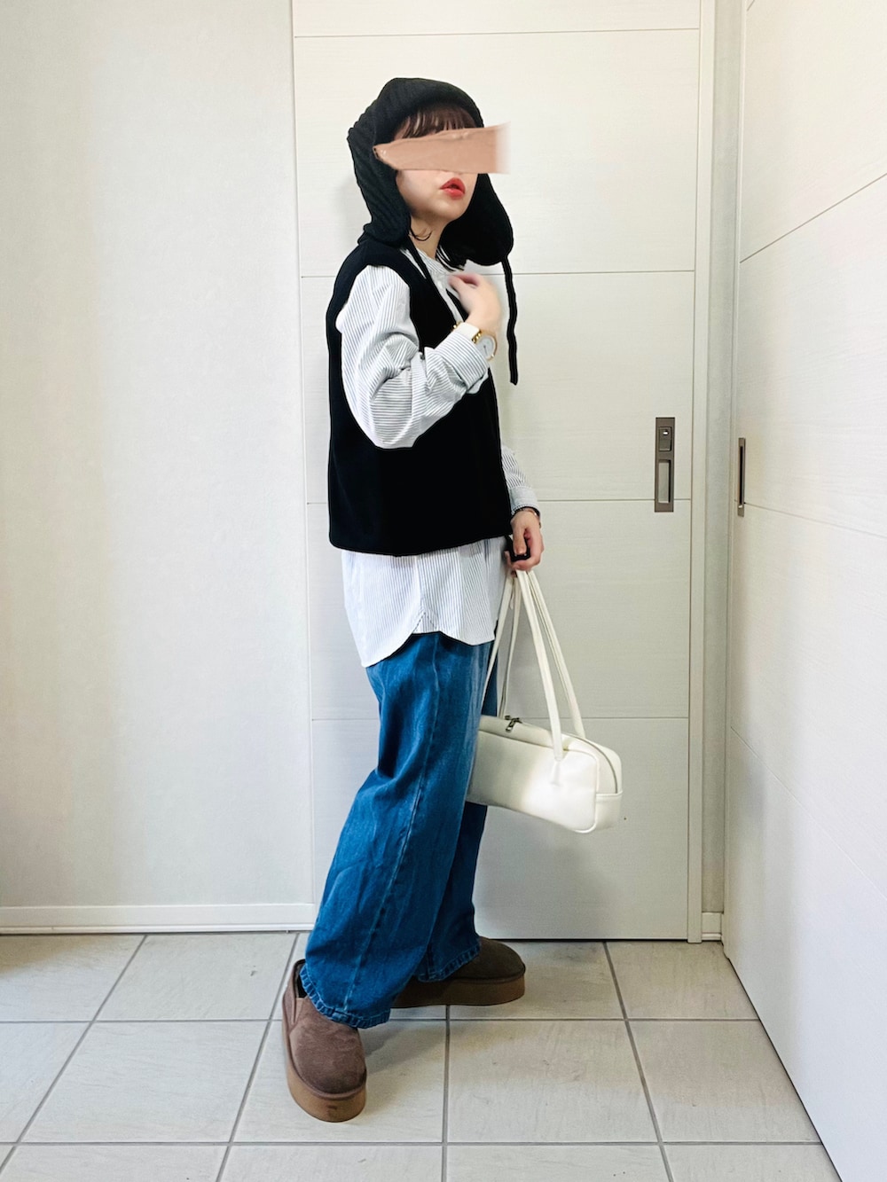 ブラック系のシャツ/ブラウス、ブルー系のデニムパンツ、ベージュ系のスリッポンを着用したレディースの秋コーディネートの2枚目の写真