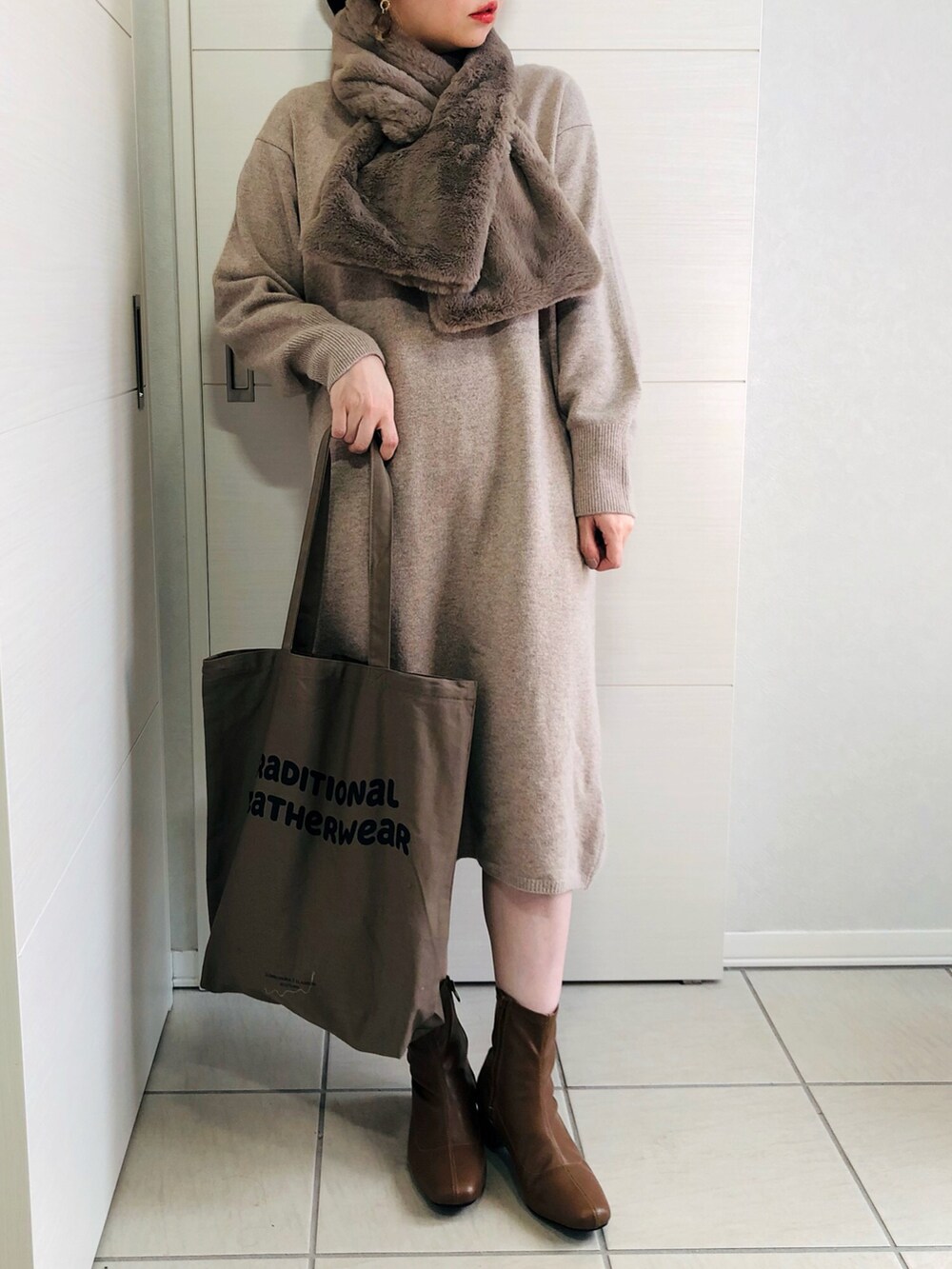 ホワイト系のノーカラーコート、ベージュ系のワンピース、ブラウン系のブーツを着用したレディースの秋コーディネートの2枚目の写真