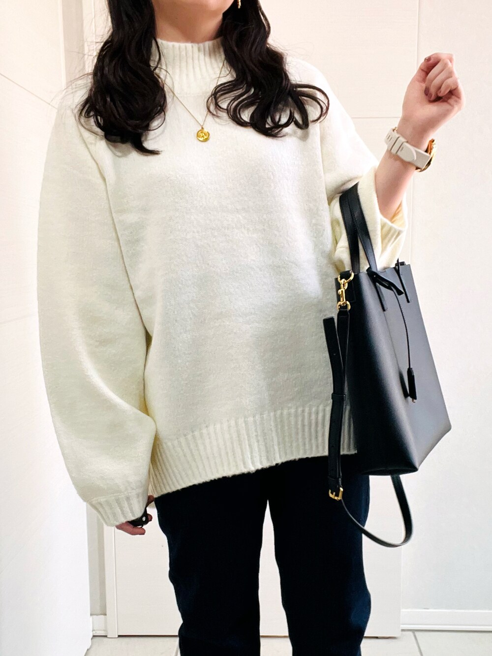 ホワイト系のニット/セーター、ブルー系のデニムパンツ、グレー系のスニーカーを着用したレディースの秋コーディネートの2枚目の写真