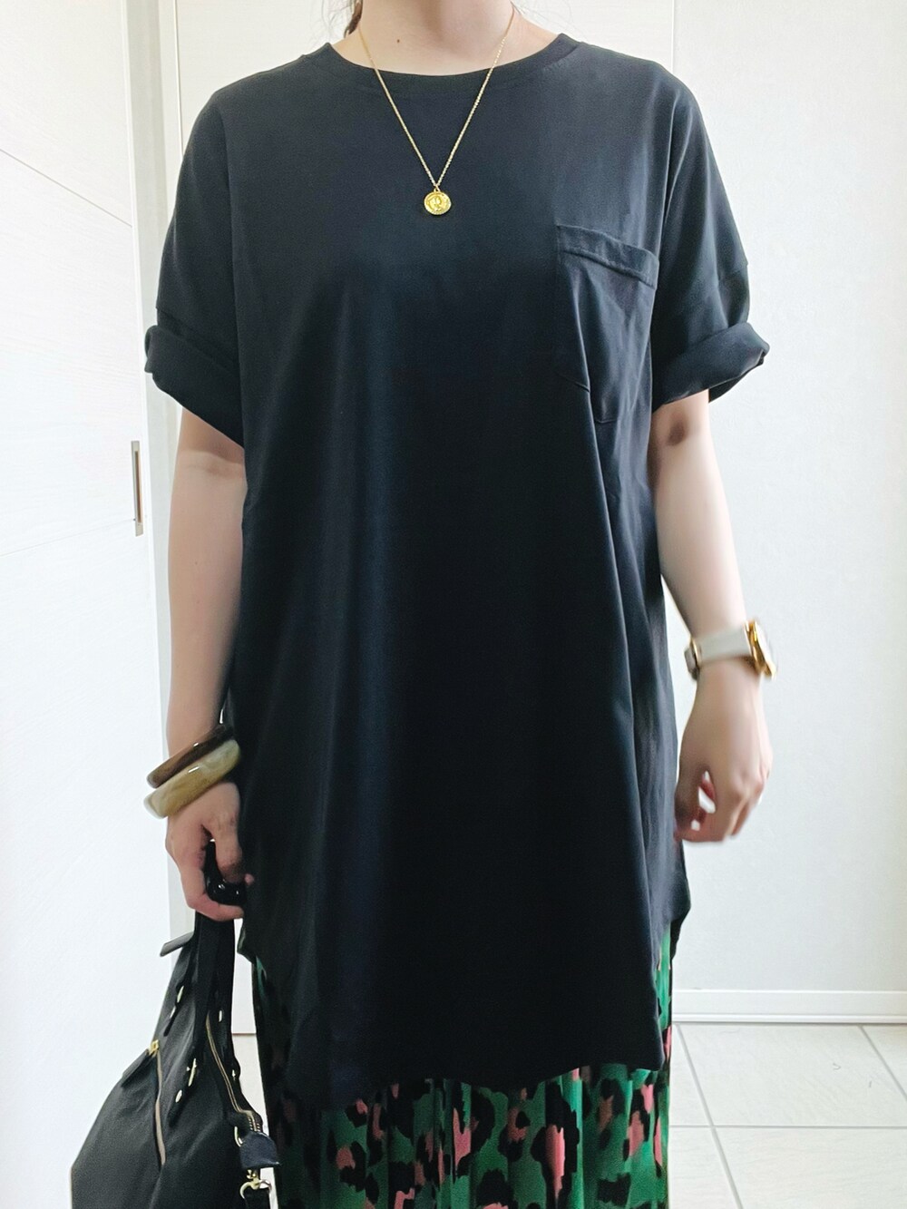 ブラック系のTシャツ/カットソー、グリーン系のスカート、ブラック系のサンダルを着用したレディースの夏コーディネートの4枚目の写真