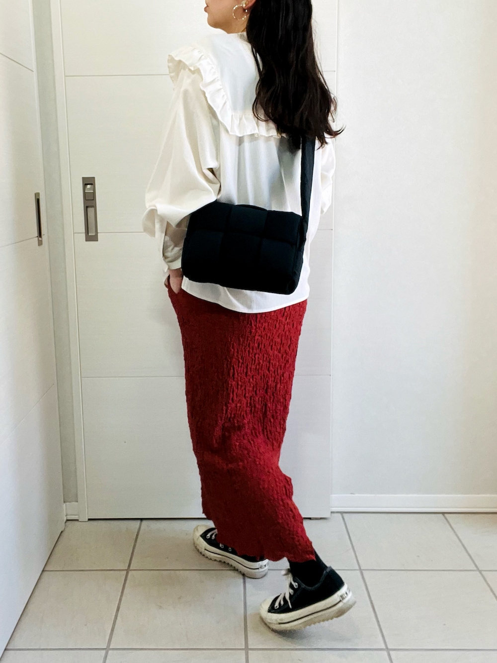 レッド系のスカート、ホワイト系のシャツ/ブラウス、ブラック系のスニーカーを着用したレディースの秋コーディネートの5枚目の写真