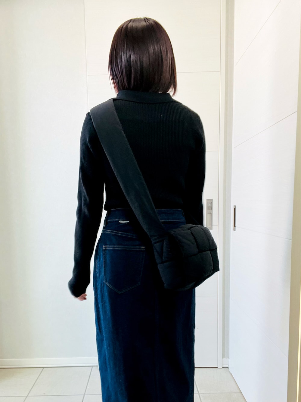 ブラック系のニット/セーター、ブルー系のスカート、ブラック系のブーツを着用したレディースの冬コーディネートの3枚目の写真