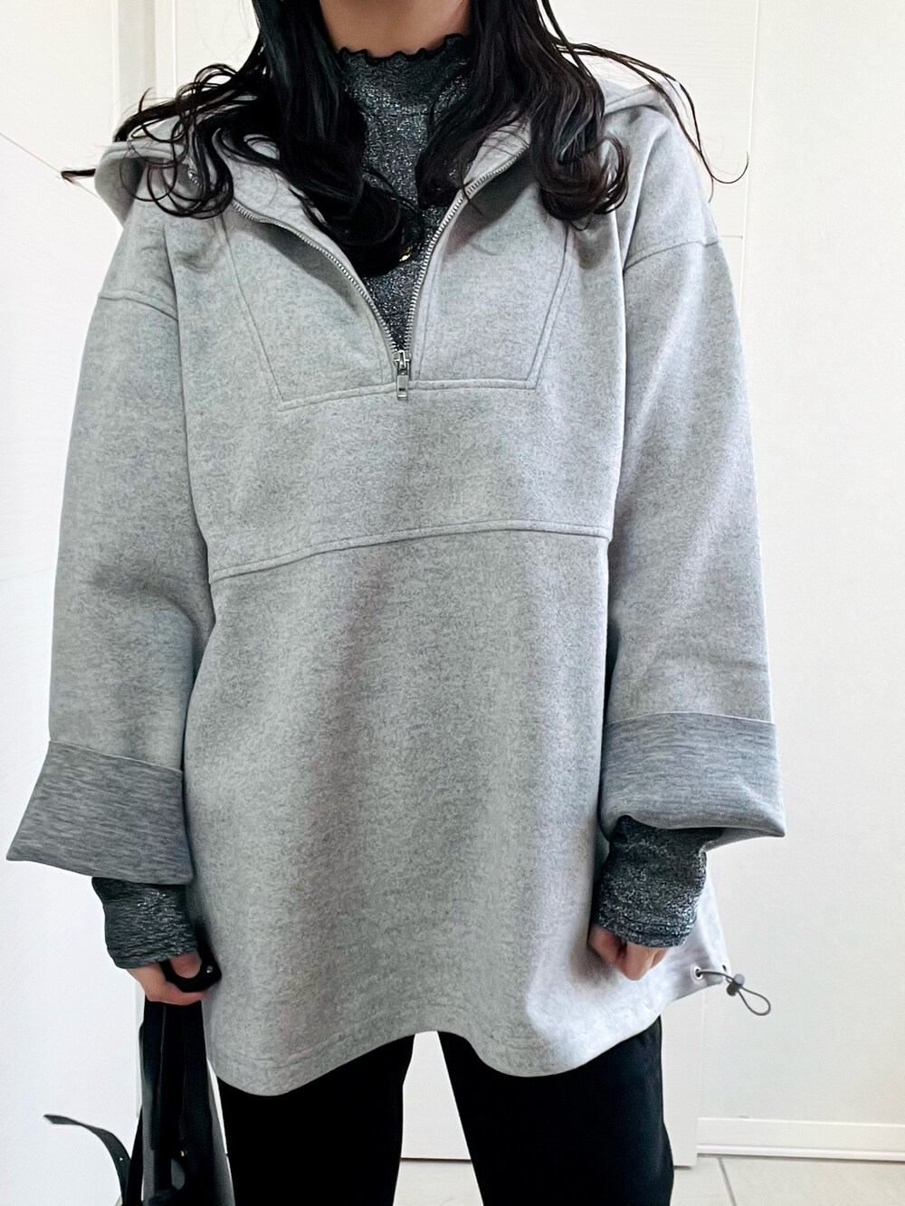 グレー系のパーカー、グレー系のTシャツ/カットソー、ブラック系のスラックスを着用したレディースの冬コーディネートの2枚目の写真