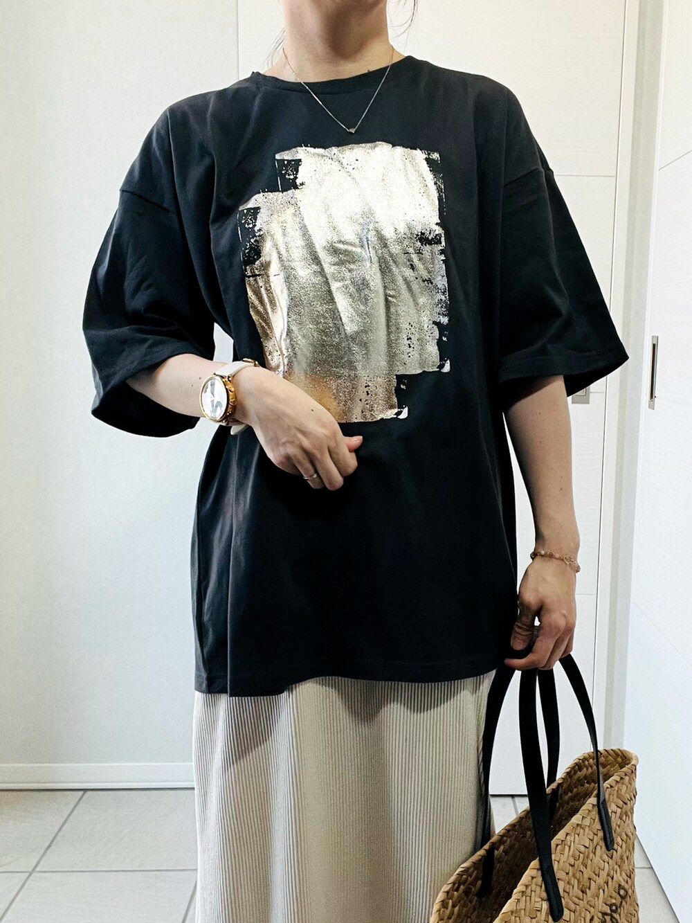 ブラック系のTシャツ/カットソー、ホワイト系のスカート、ホワイト系のスニーカーを着用したレディースの夏コーディネートの2枚目の写真