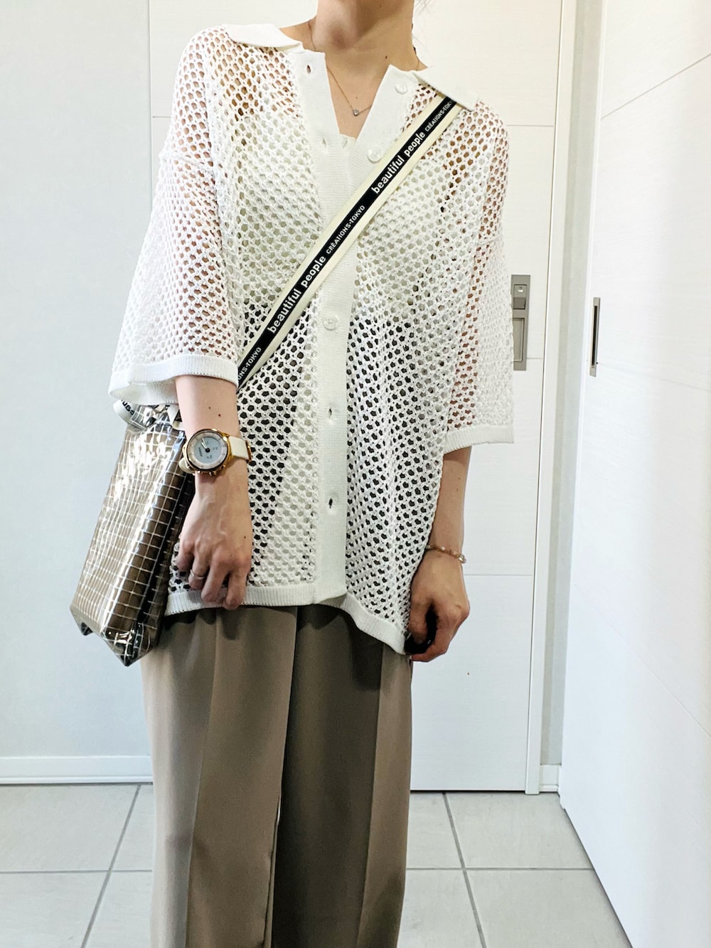 ホワイト系のシャツ/ブラウス、ベージュ系のスラックス、ホワイト系のスニーカーを着用したレディースの夏コーディネートの2枚目の写真