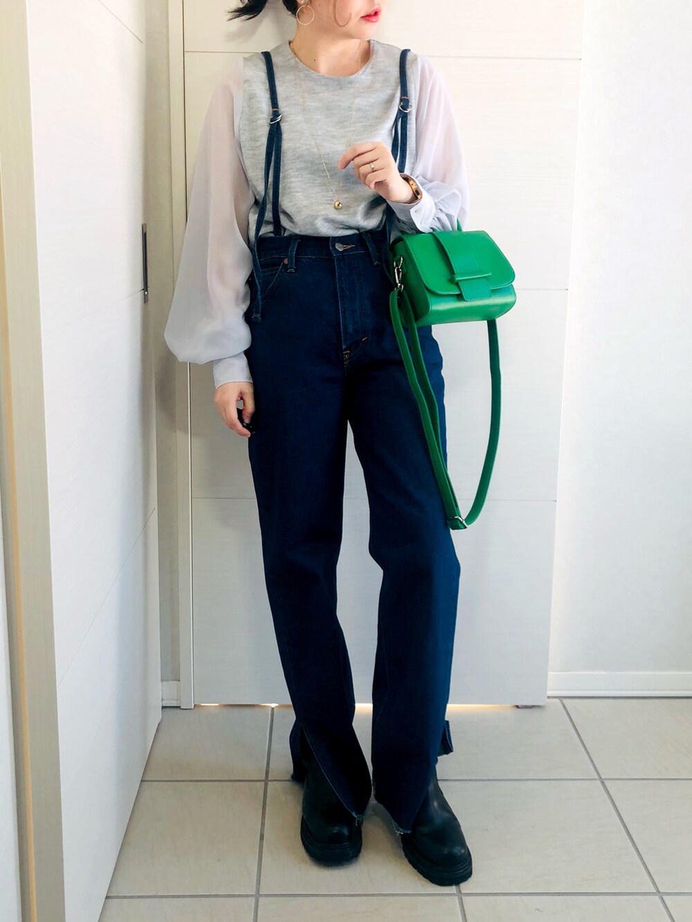 グレー系のTシャツ/カットソー、ブルー系のデニムパンツ、ブラック系のブーツを着用したレディースの冬コーディネートの2枚目の写真