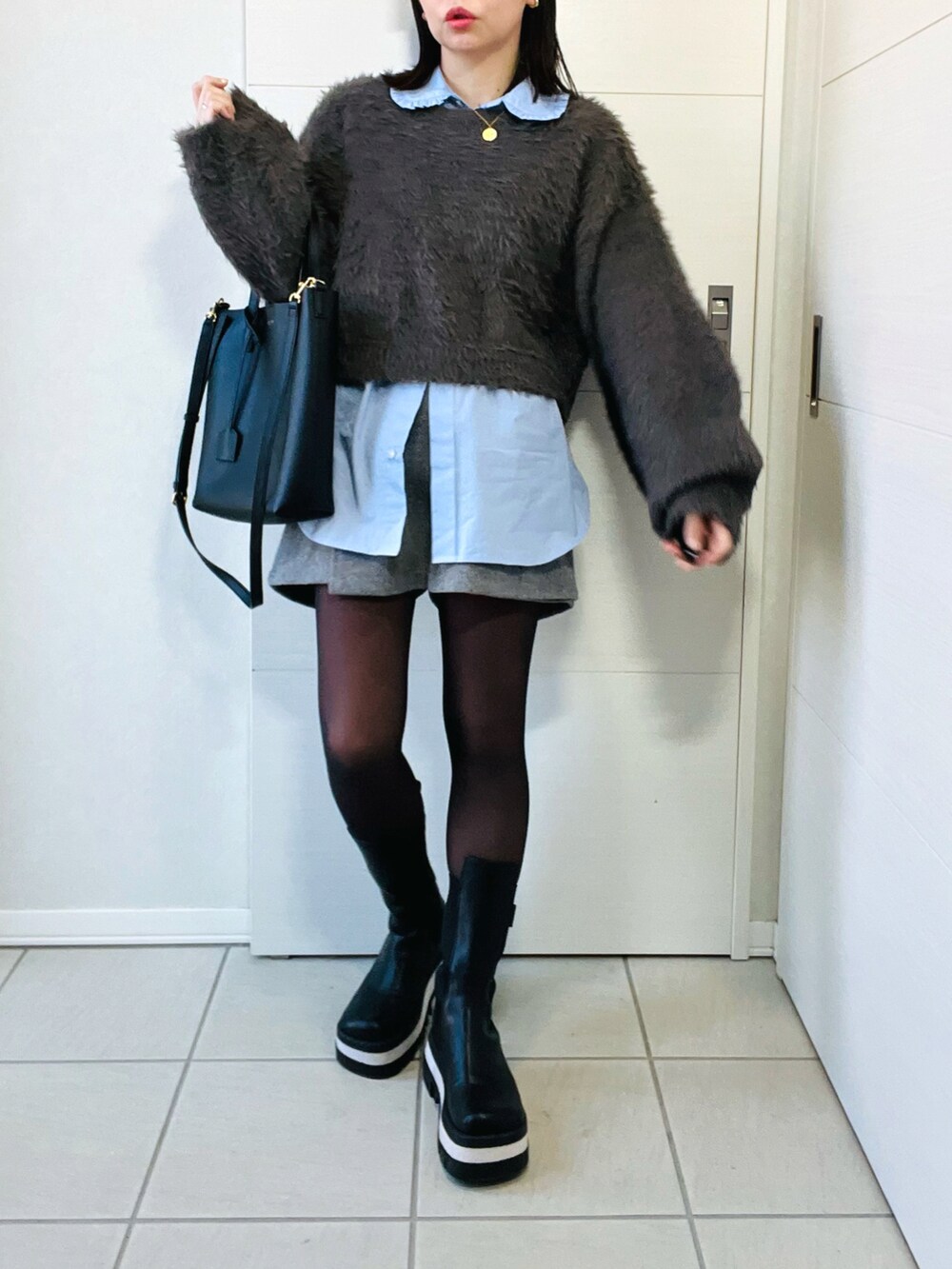 グレー系のニット/セーター、ブルー系のシャツ/ブラウス、グレー系のその他パンツを着用したレディースの冬コーディネートの3枚目の写真