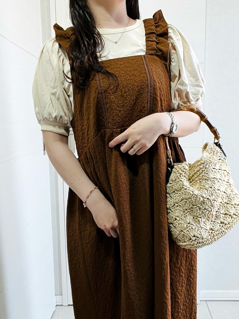 ブラウン系のワンピース、グレー系のサンダル、ベージュ系のショルダーバッグを着用したレディースの春コーディネートの3枚目の写真