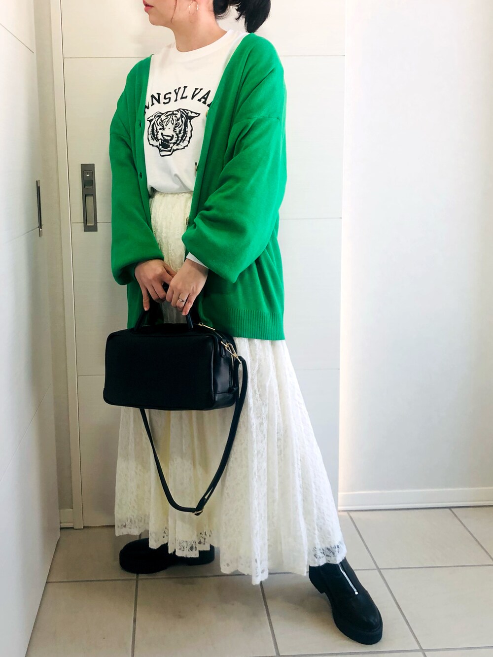 グリーン系のカーディガン/ボレロ、ホワイト系のTシャツ/カットソー、ホワイト系のスカートを着用したレディースの冬コーディネートの3枚目の写真