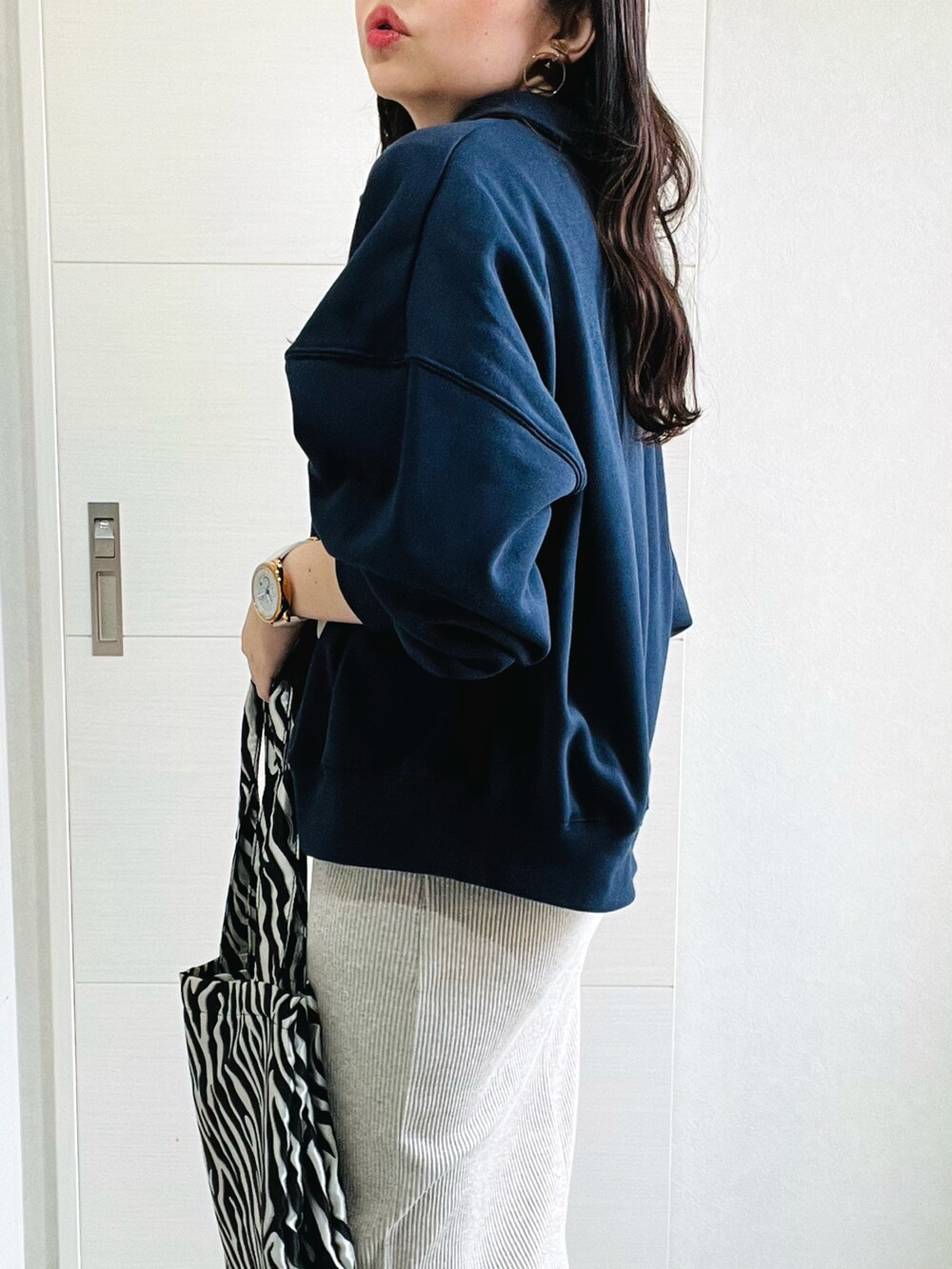 ブルー系のスウェット、ベージュ系のスカート、ホワイト系のスニーカーを着用したレディースの秋コーディネートの4枚目の写真