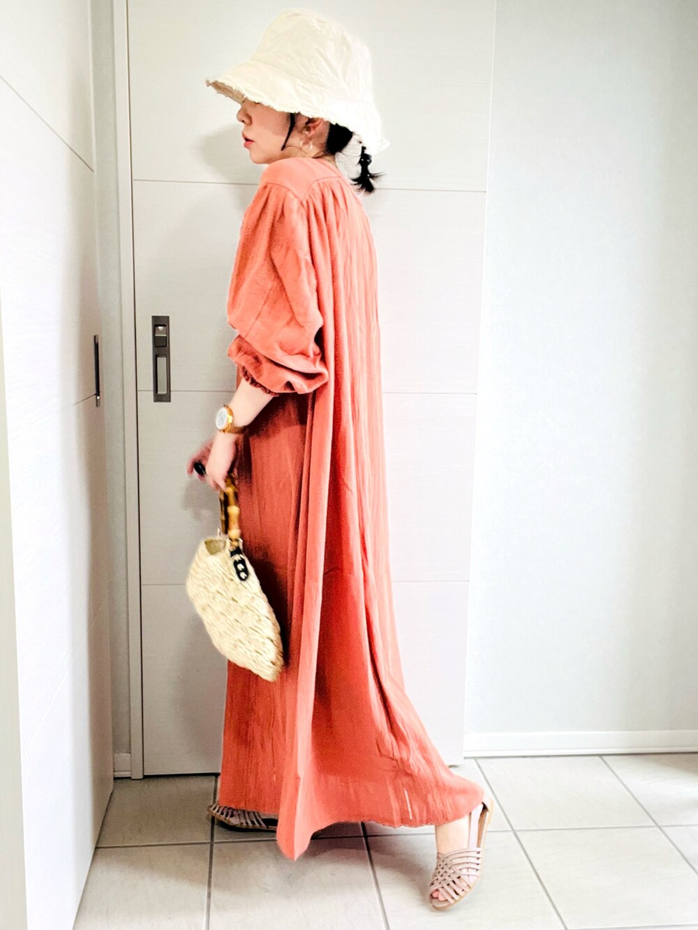 ピンク系のワンピース、グレー系のサンダル、ベージュ系のショルダーバッグを着用したレディースの夏コーディネートの4枚目の写真