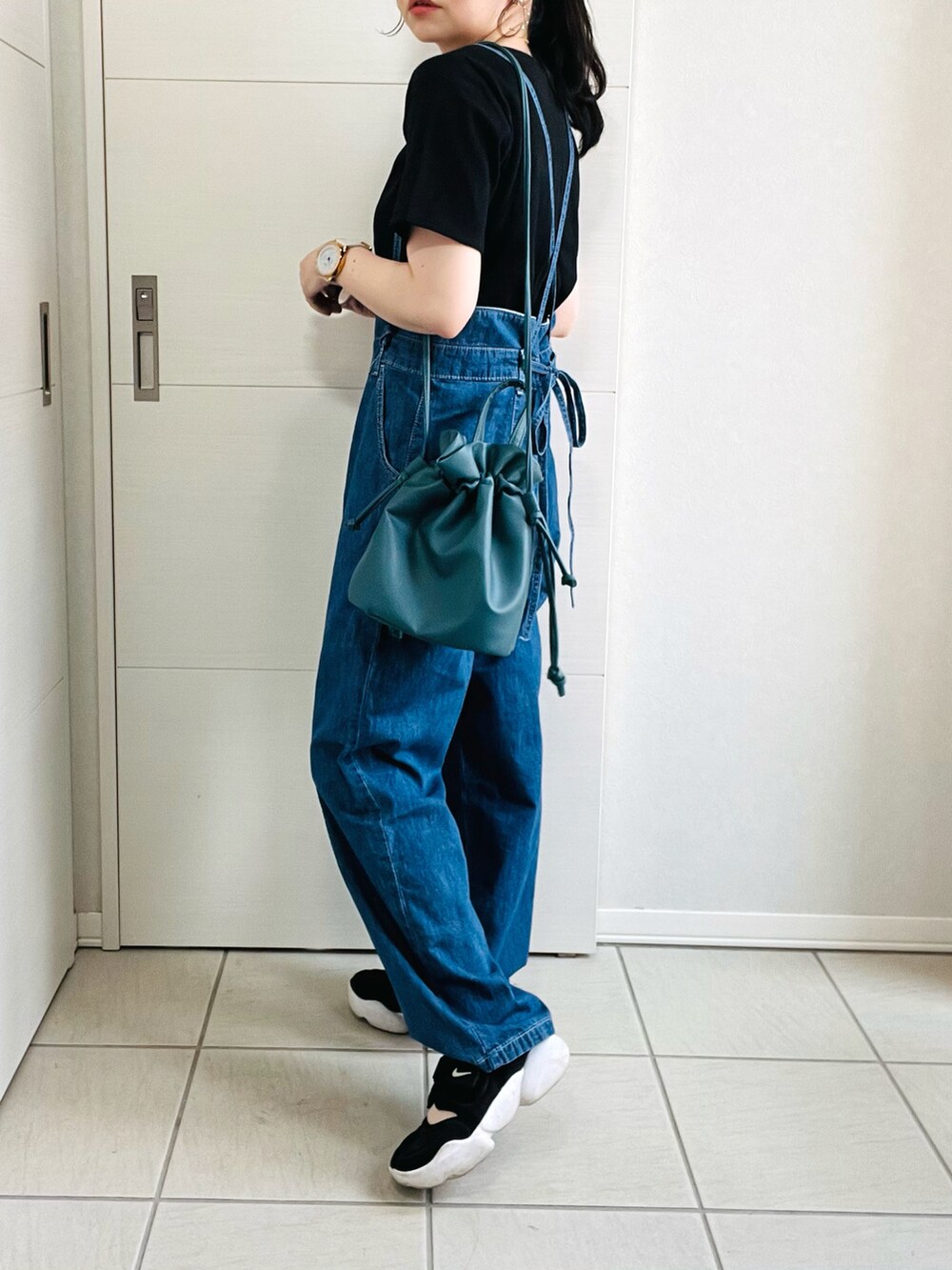 ブルー系のサロペット/オーバーオール、ブラック系のTシャツ/カットソー、ブラック系のスニーカーを着用したレディースの夏コーディネートの5枚目の写真
