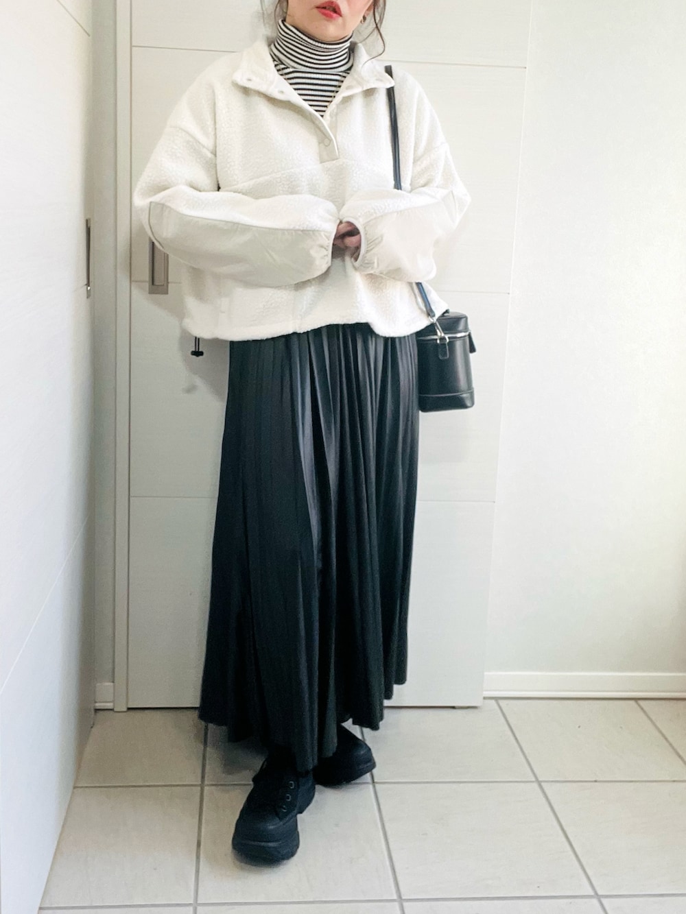 ホワイト系のTシャツ/カットソー、その他のニット/セーター、ブラック系のスカートを着用したレディースの冬コーディネートの3枚目の写真