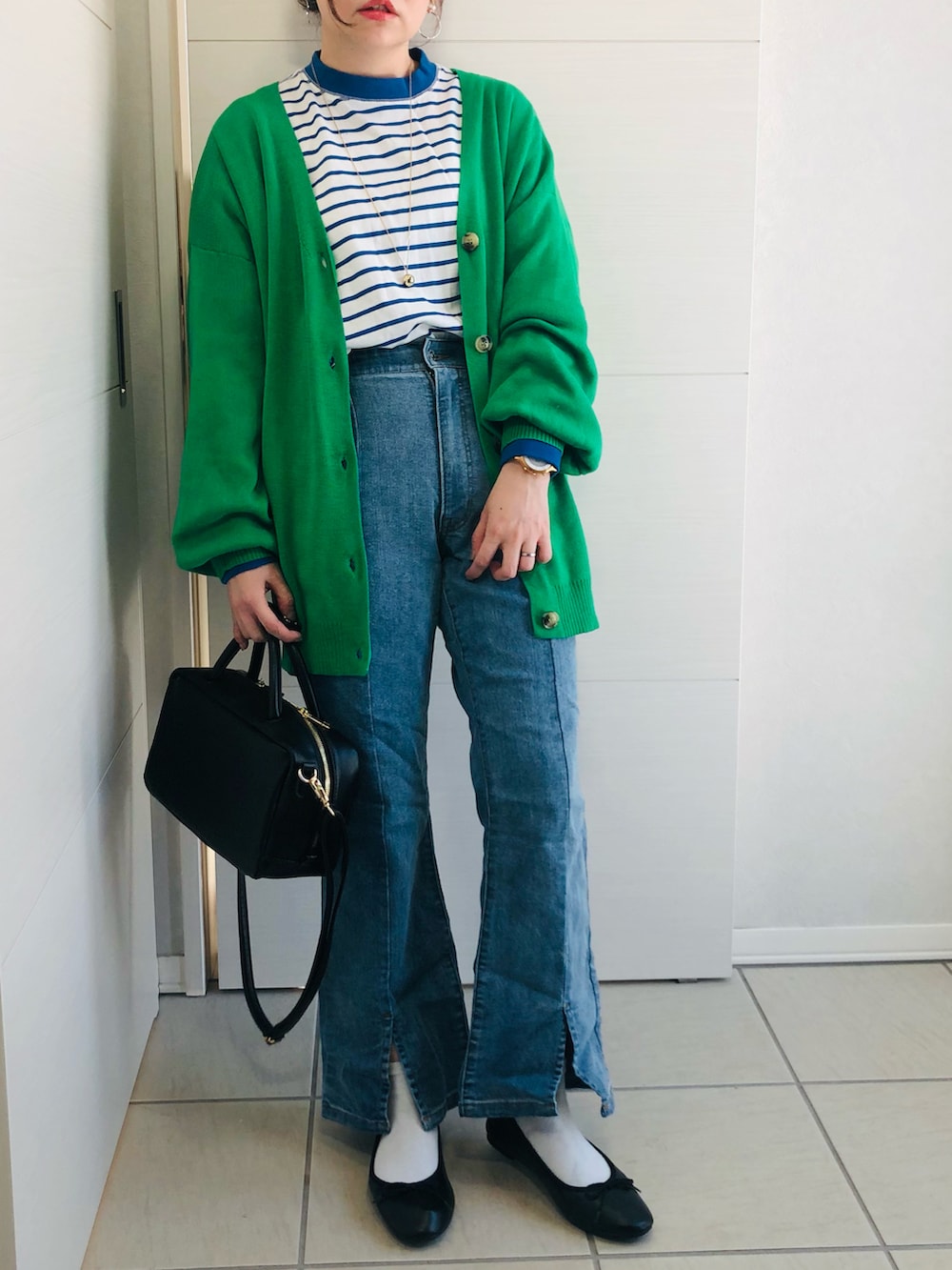 グリーン系のカーディガン/ボレロ、ブルー系のTシャツ/カットソー、ブルー系のデニムパンツを着用したレディースの冬コーディネートの2枚目の写真