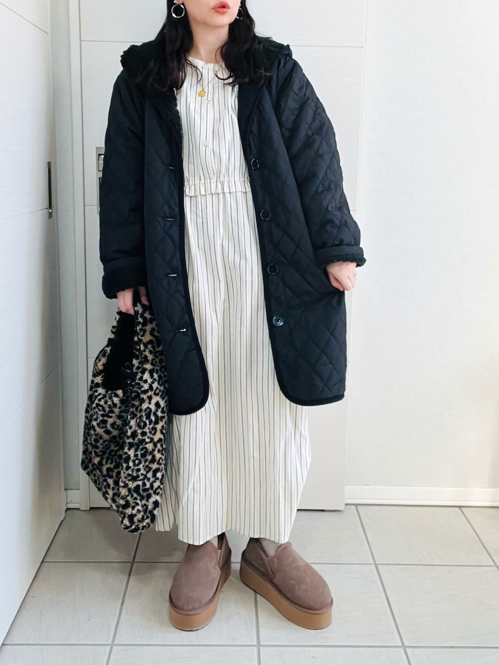 ブラック系のナイロンジャケット、ブルー系のワンピース、ベージュ系のスリッポンを着用したレディースの冬コーディネートの2枚目の写真