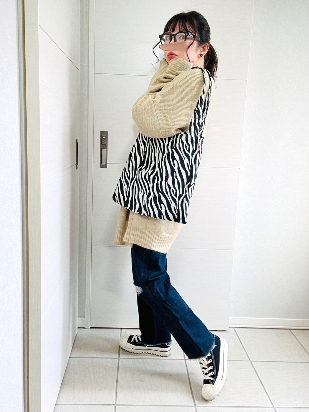 ベージュ系のカーディガン/ボレロ、ホワイト系のTシャツ/カットソー、ブルー系のデニムパンツを着用したレディースの秋コーディネートの5枚目の写真