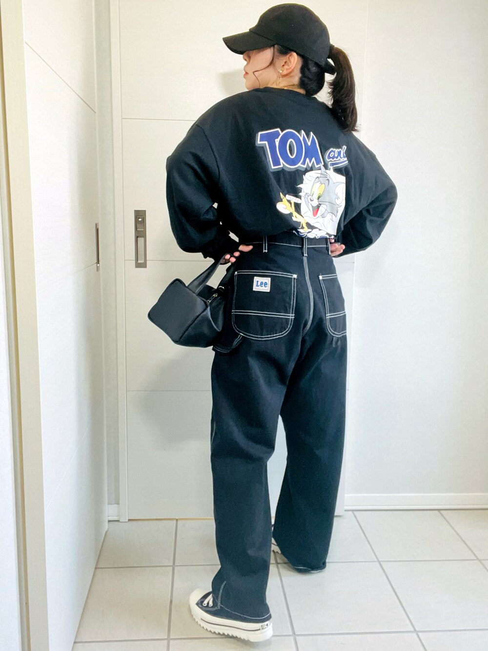 ブラック系のTシャツ/カットソー、ブラック系のデニムパンツ、ブラック系のスニーカーを着用したレディースの秋コーディネートの2枚目の写真