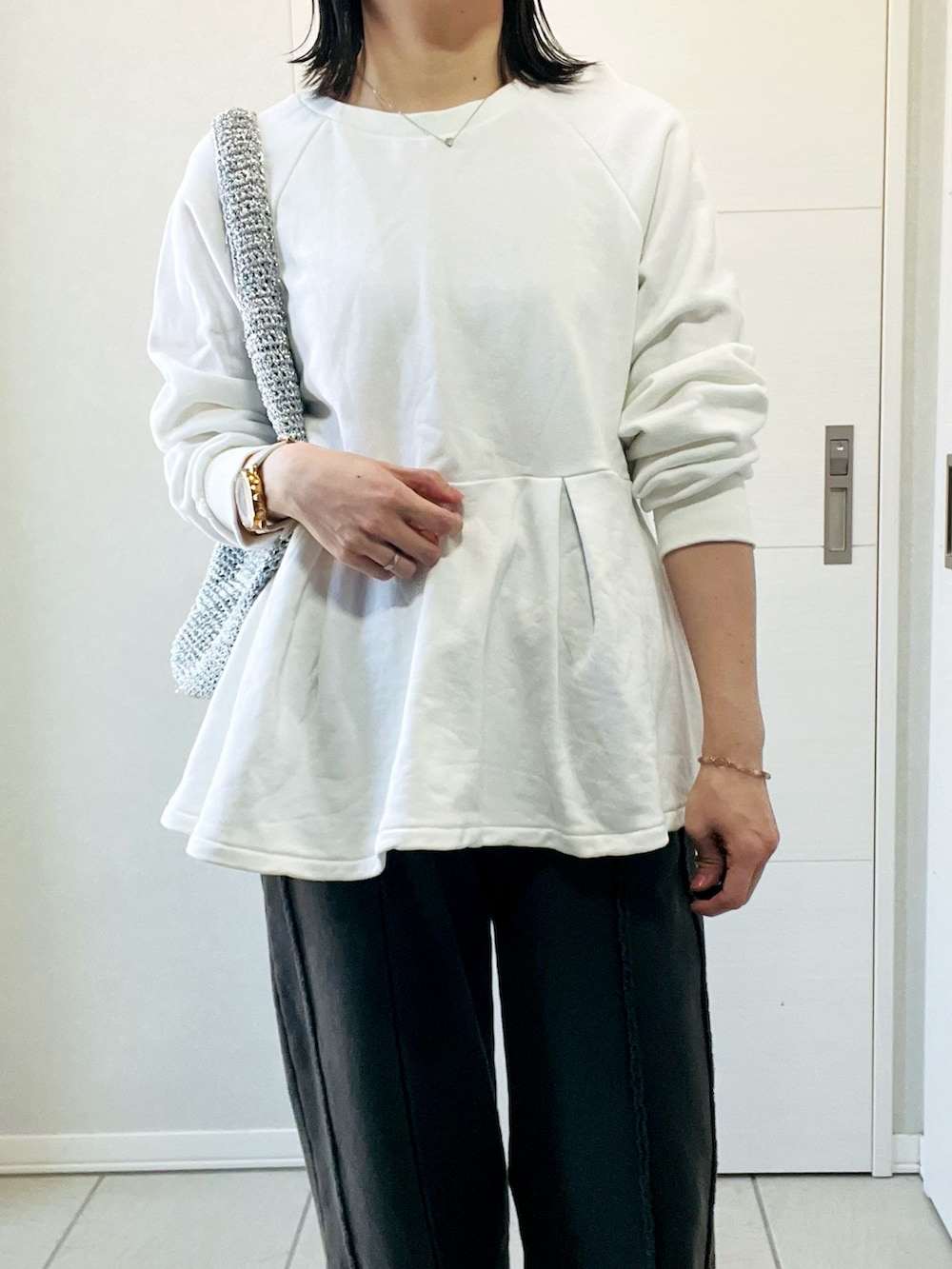 ホワイト系のスウェット、ブラック系のスウェットパンツ、レッド系のスニーカーを着用したレディースの春コーディネートの2枚目の写真