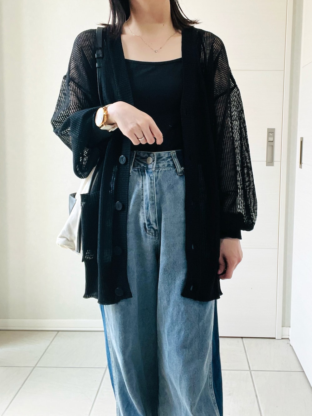 ブラック系のカーディガン/ボレロ、ブルー系のデニムパンツ、ホワイト系のスニーカーを着用したレディースの夏コーディネートの2枚目の写真