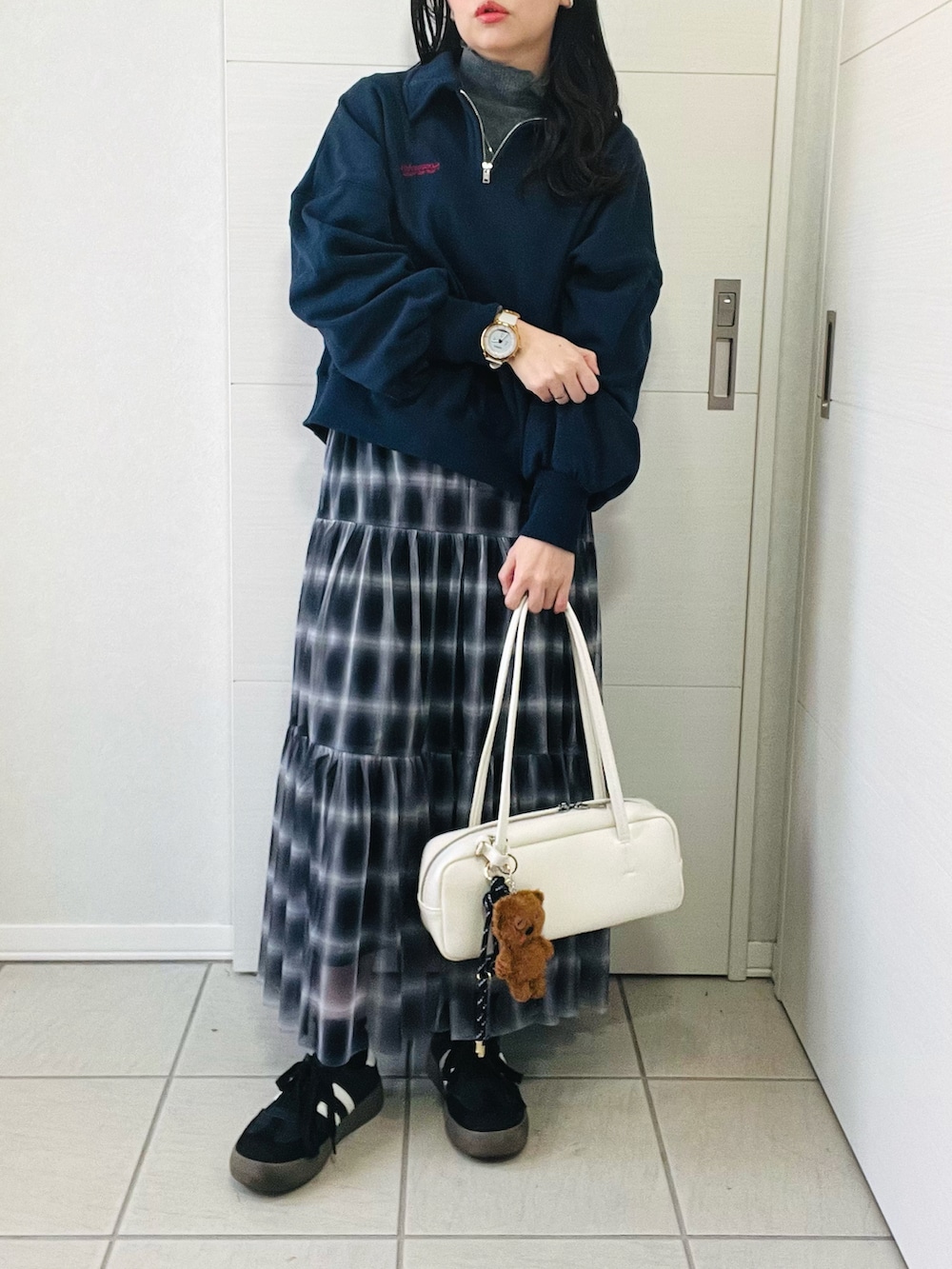 ブラック系のスカート、ブルー系のスウェット、ホワイト系のボストンバッグを着用したレディースの秋コーディネートの3枚目の写真