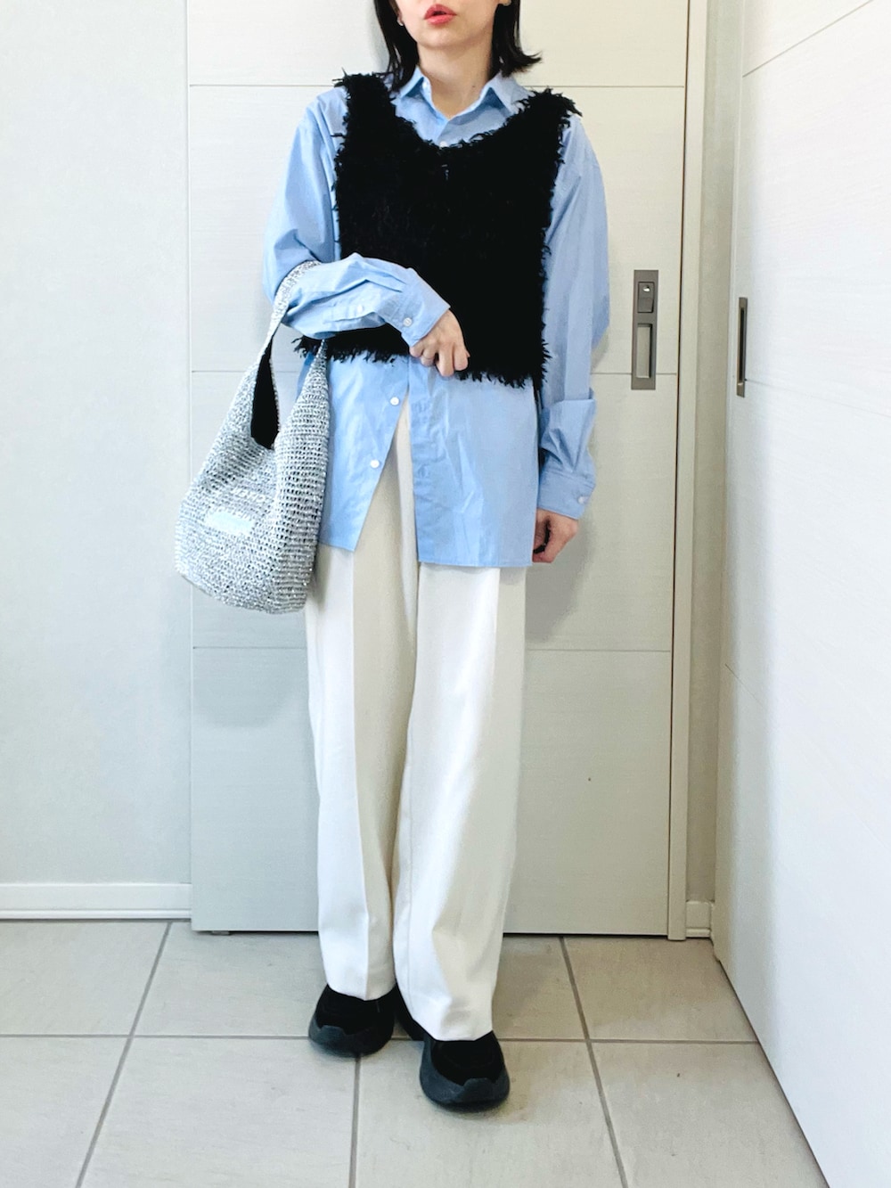 ブラック系のベスト、ブルー系のシャツ/ブラウス、ホワイト系のスラックスを着用したレディースの春コーディネートの4枚目の写真