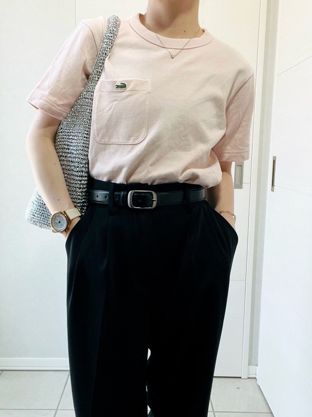 ブラック系のスラックス、ピンク系のTシャツ/カットソー、シルバー系のショルダーバッグを着用したレディースの夏コーディネートの2枚目の写真