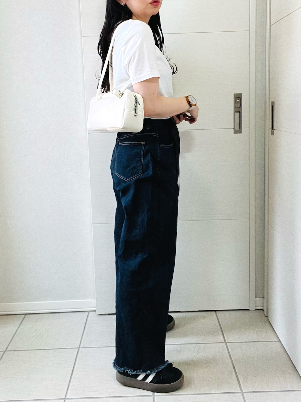 ホワイト系のTシャツ/カットソー、ブルー系のデニムパンツ、ブラック系のスニーカーを着用したレディースの夏コーディネートの5枚目の写真