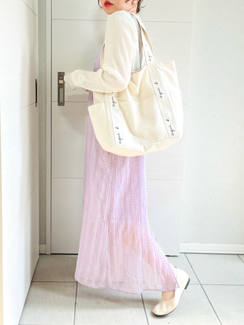 パープル系のワンピース、ホワイト系のバレエシューズ、ベージュ系のトートバッグを着用したレディースの春コーディネートの3枚目の写真