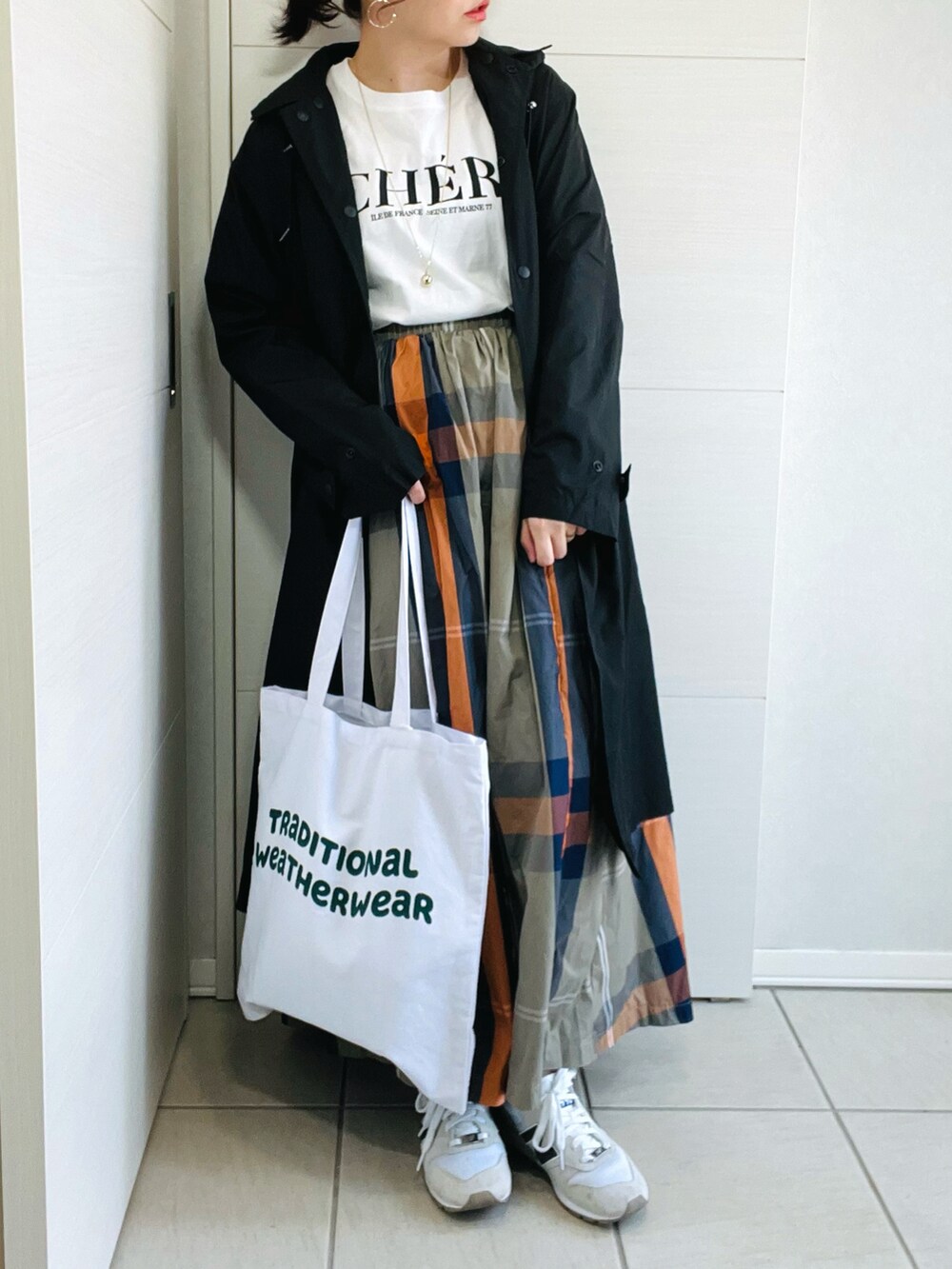 ホワイト系のトートバッグ、グリーン系のスカート、ホワイト系のスニーカーを着用したレディースの春コーディネートの2枚目の写真