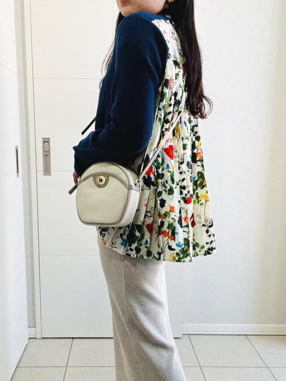 ブルー系のカーディガン/ボレロ、ベージュ系のスカート、ホワイト系のスニーカーを着用したレディースの春コーディネートの3枚目の写真