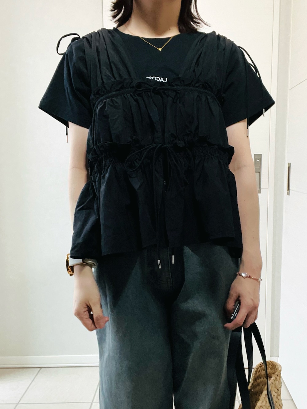 ブラック系のシャツ/ブラウス、ブラック系のTシャツ/カットソー、ブルー系のデニムパンツを着用したレディースの夏コーディネートの2枚目の写真