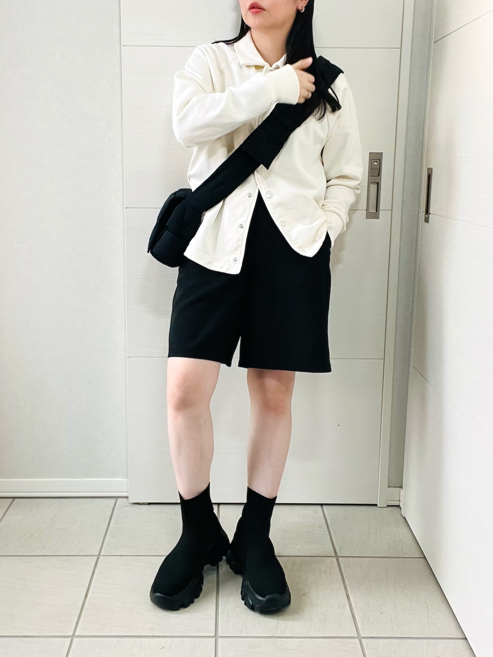 ホワイト系のスウェット、ブラック系のその他パンツ、ブラック系のブーツを着用したレディースの秋コーディネートの4枚目の写真