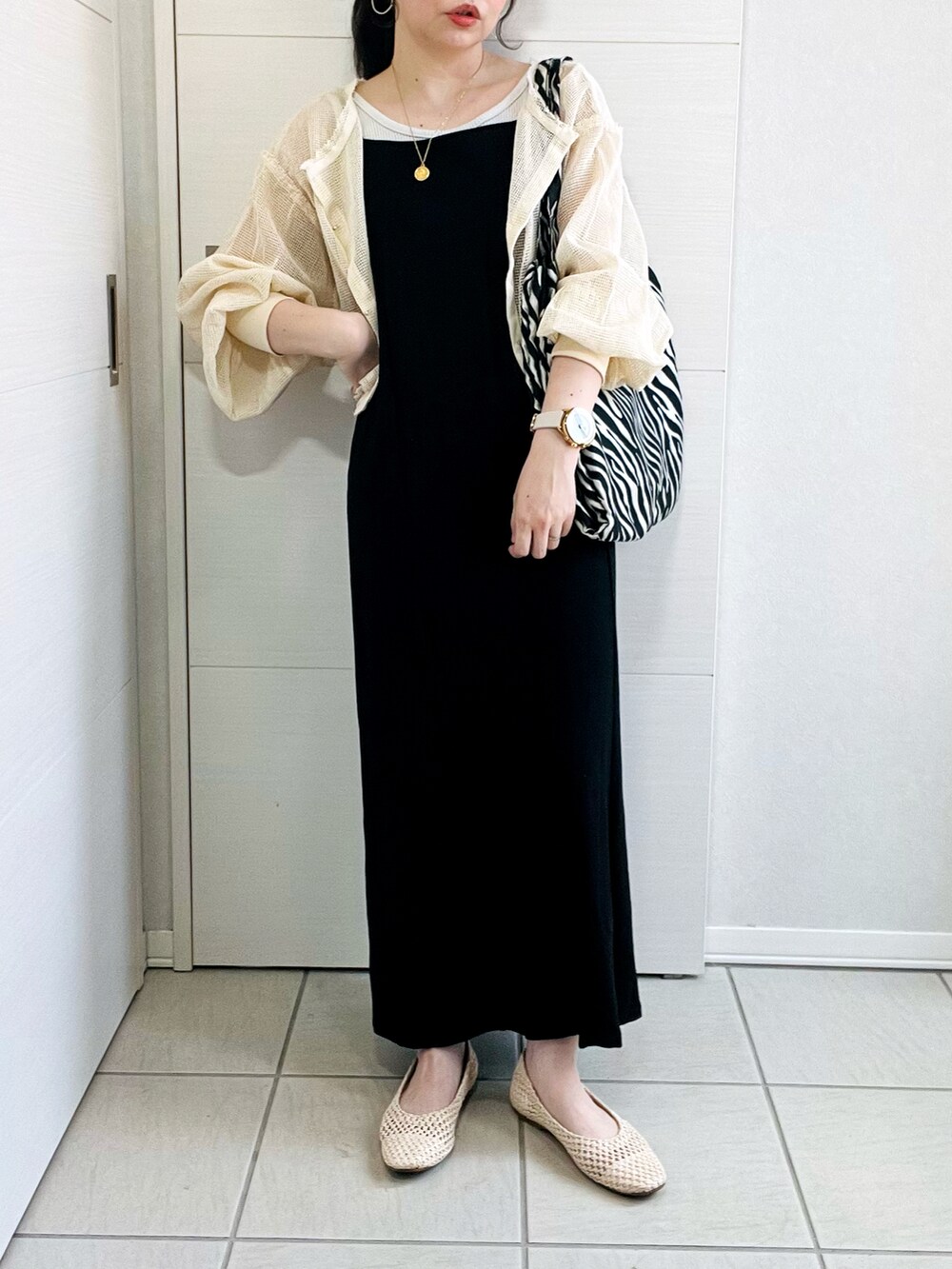 ホワイト系のカーディガン/ボレロ、ブラック系のワンピース、ベージュ系のパンプスを着用したレディースの春コーディネートの4枚目の写真