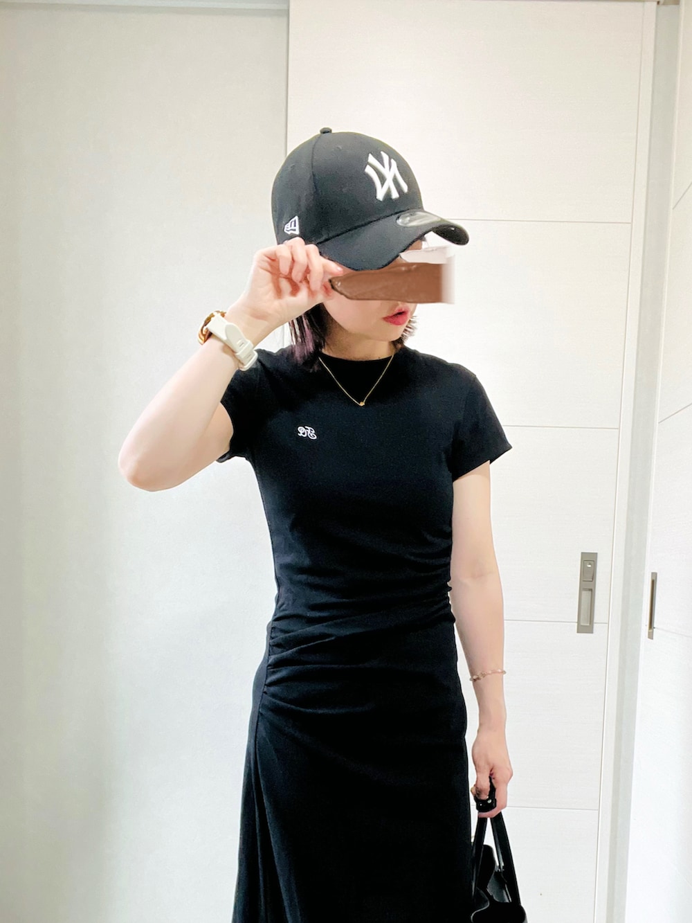 ブラック系のワンピース、レッド系のスニーカー、ブラック系のトートバッグを着用したレディースの夏コーディネートの2枚目の写真