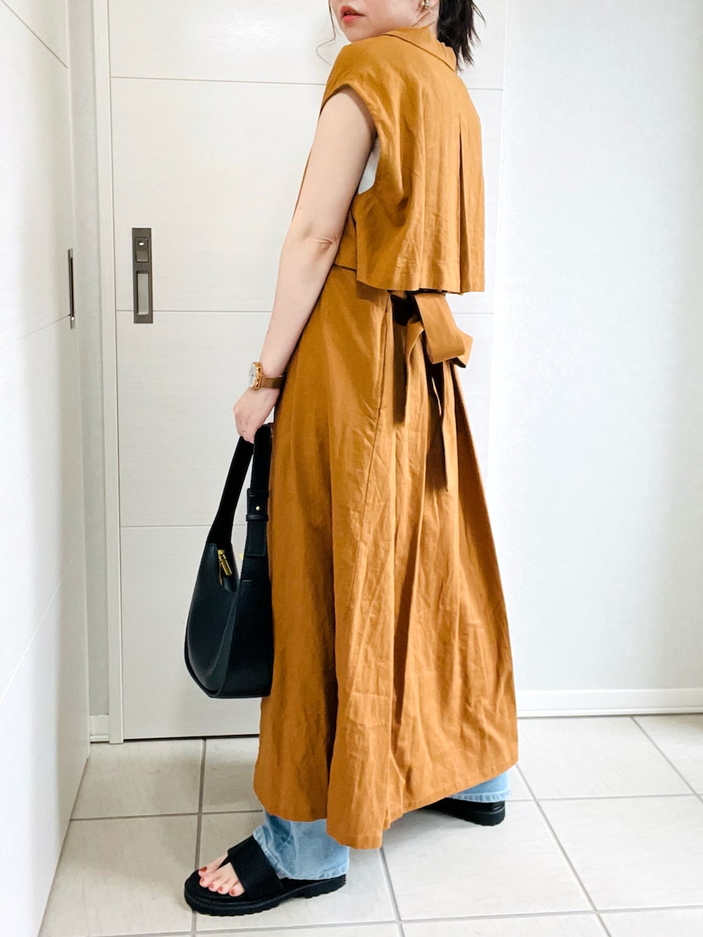 ブラウン系のワンピース、ブルー系のデニムパンツ、ブラック系のサンダルを着用したレディースの夏コーディネートの4枚目の写真