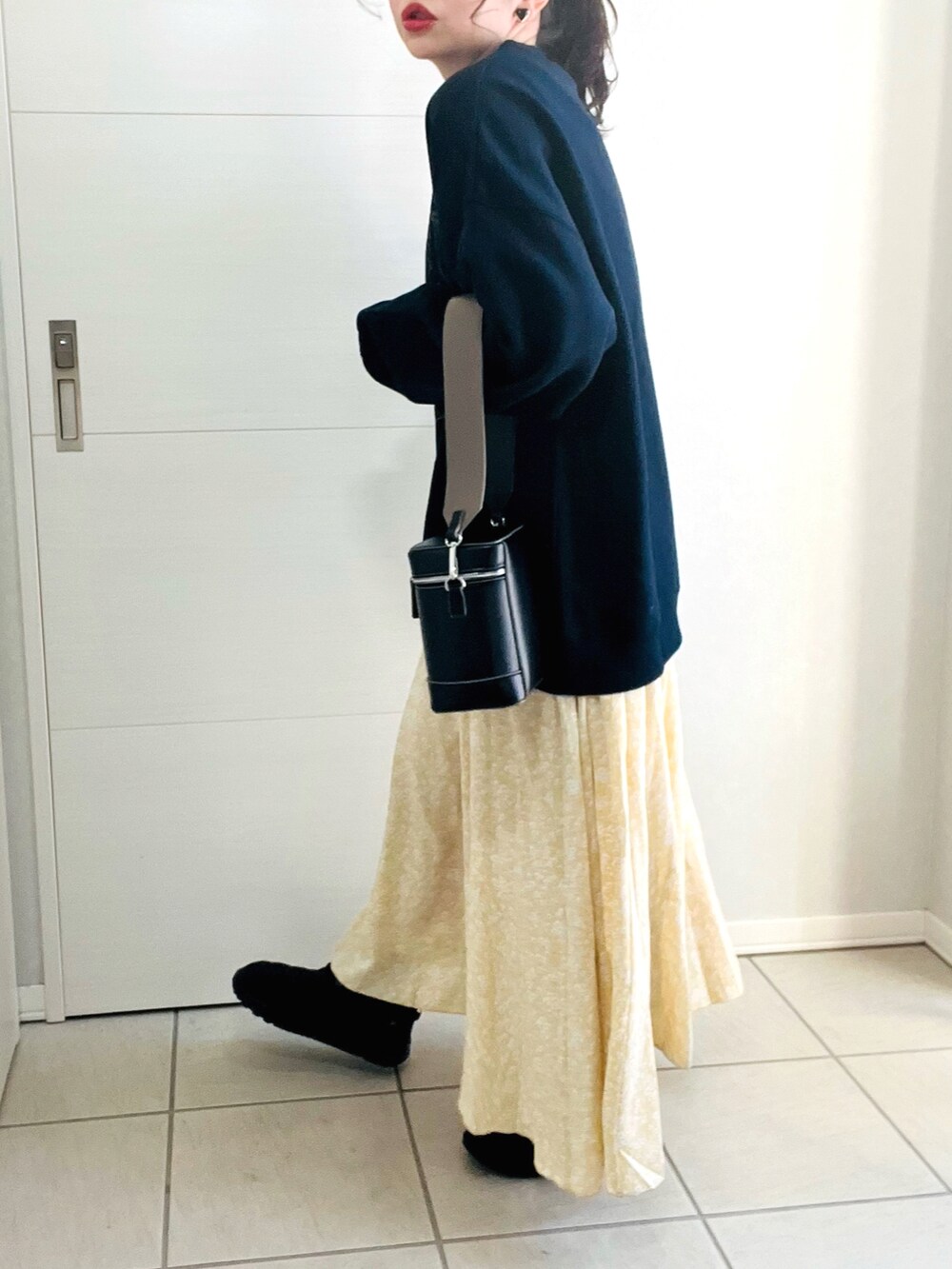 ブルー系のスウェット、イエロー系のスカート、ブラック系のスニーカーを着用したレディースの冬コーディネートの5枚目の写真