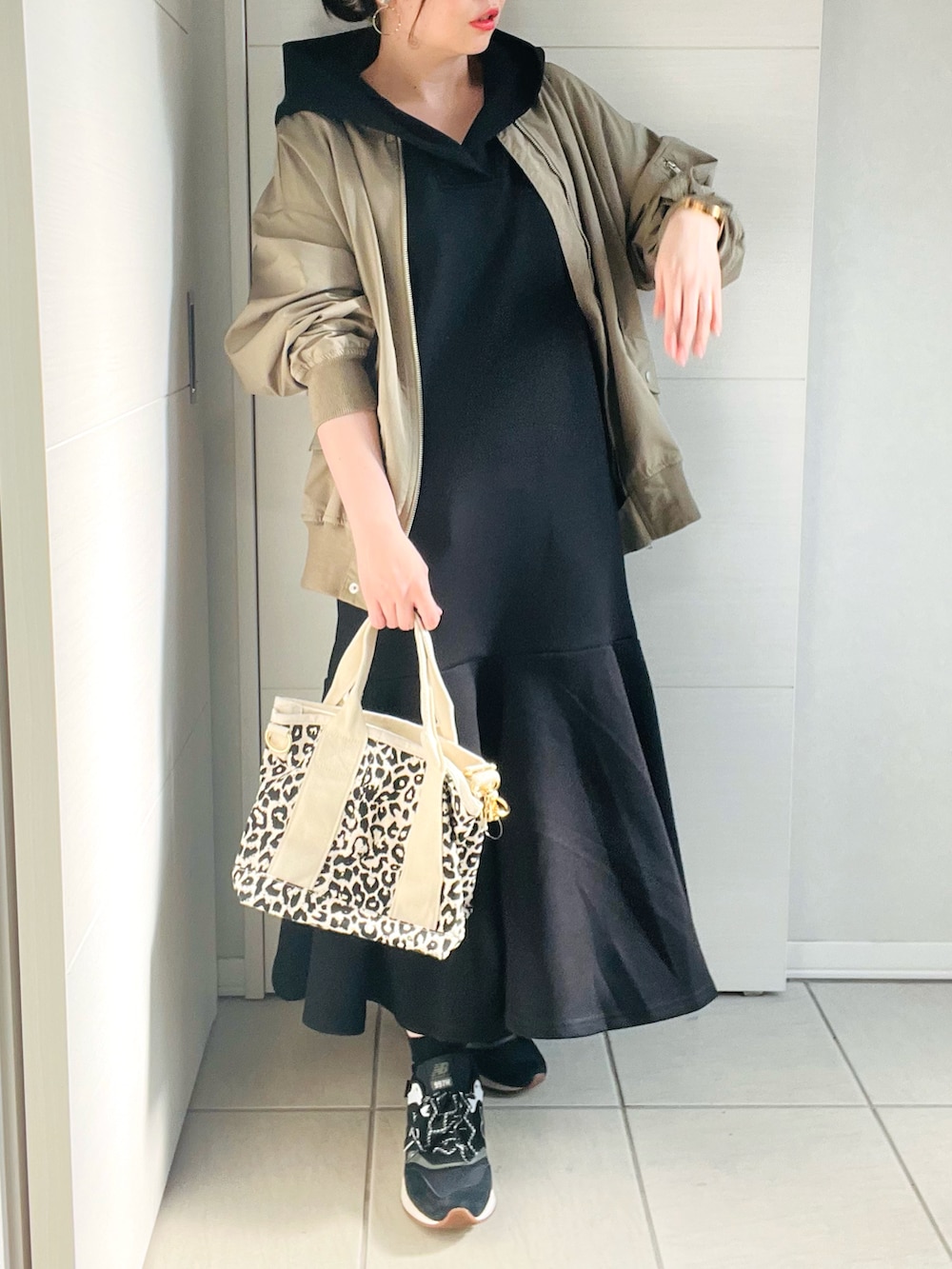 グリーン系のMA-1、ブラック系のワンピース、ブラック系のスニーカーを着用したレディースの春コーディネートの2枚目の写真