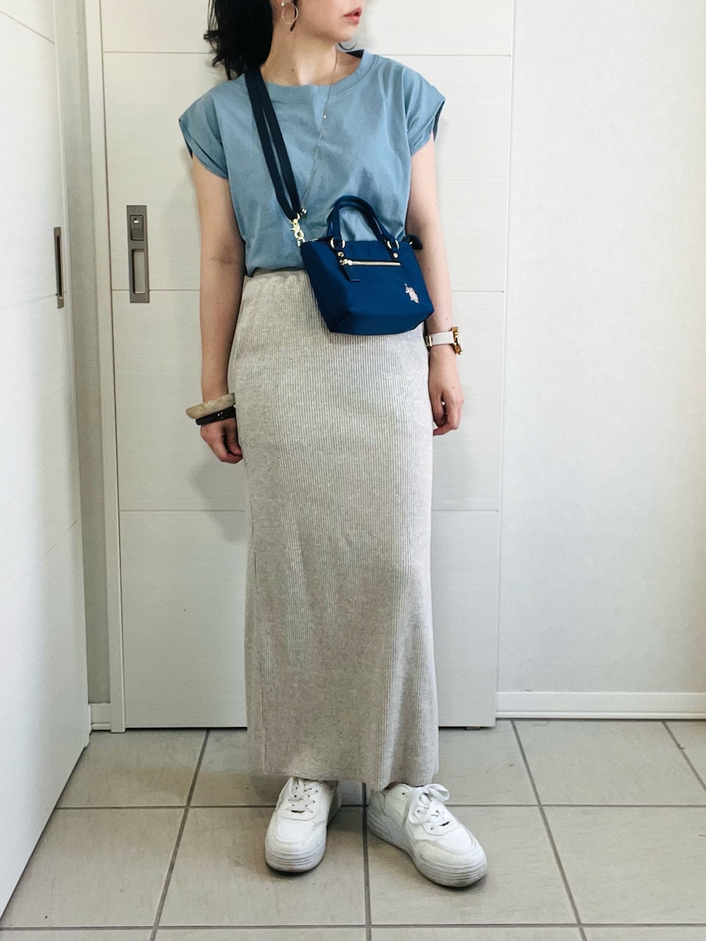 ブルー系のTシャツ/カットソー、ベージュ系のスカート、ホワイト系のスニーカーを着用したレディースの夏コーディネートの2枚目の写真