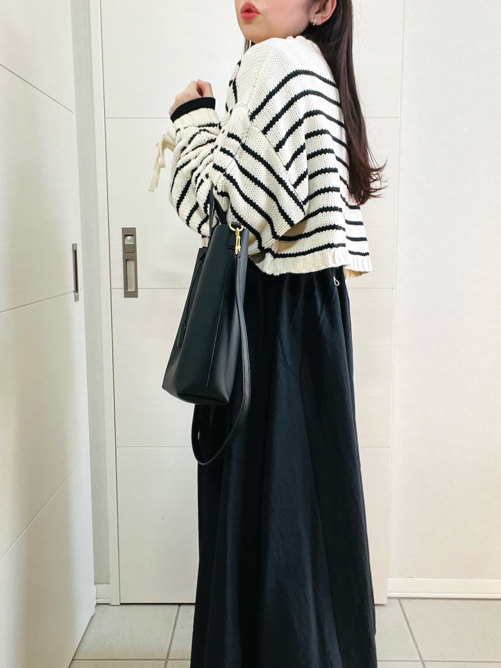 その他のニット/セーター、グリーン系のワンピース、ブラック系のブーツを着用したレディースの冬コーディネートの3枚目の写真