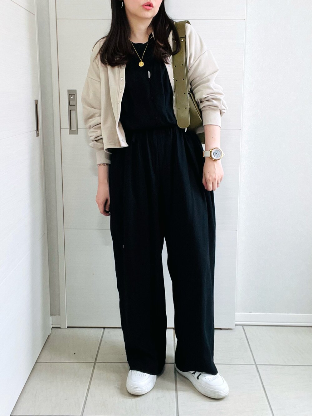 ブラック系のサロペット/オーバーオール、ベージュ系のカーディガン/ボレロ、ホワイト系のスニーカーを着用したレディースの夏コーディネートの4枚目の写真