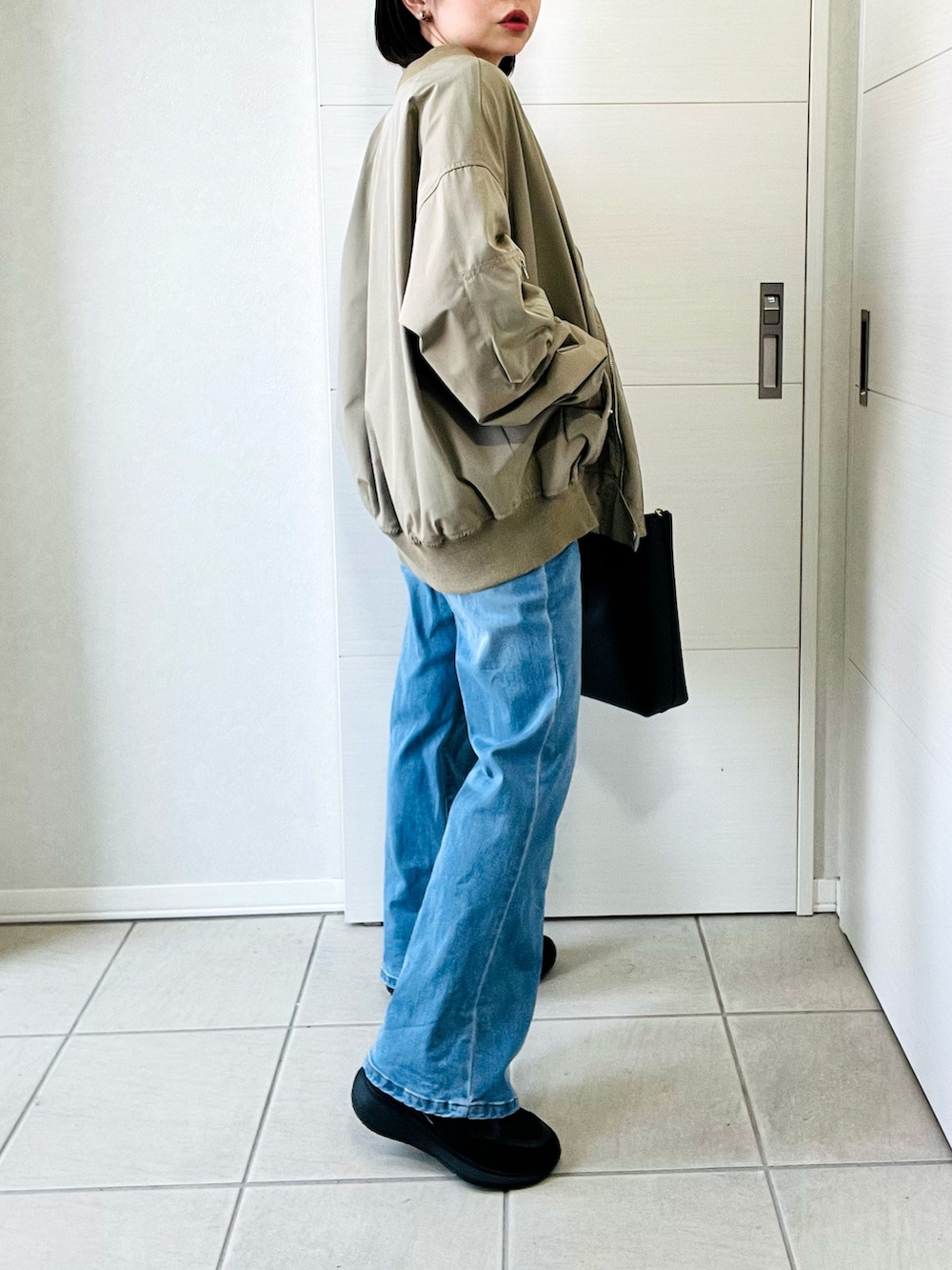 ホワイト系のTシャツ/カットソー、グリーン系のMA-1、ブルー系のデニムパンツを着用したレディースの春コーディネートの4枚目の写真